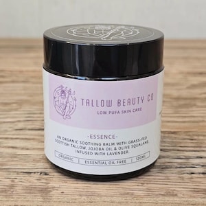 May include: A 120ml jar of Tallow Beauty Co. Essence skin care balm. The label is white with a light purple accent, featuring a circular logo of a figure holding a staff. Text includes: Organic, Low Pufa Skin Care, and Essential Oil Free.