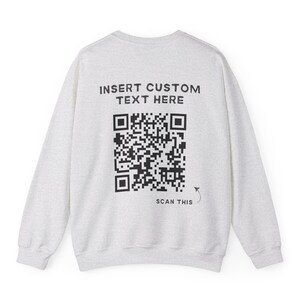 May include: A gray sweatshirt with a black QR code and the text "INSERT CUSTOM TEXT HERE" and "SCAN THIS" printed on the back.