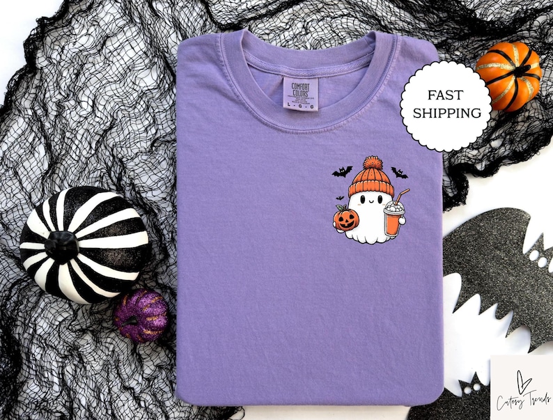 Pu&ograve; includere: Maglietta viola con un simpatico fantasma dei cartoni animati che indossa un cappello a forma di zucca e tiene una zucca e una bevanda. Il fantasma indossa un cappello marrone con un pon pon bianco. Il fantasma sorride e ha un'espressione amichevole. La maglietta &egrave; un ottimo regalo per Halloween.