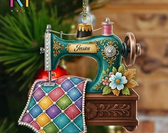 May include: A teal sewing machine Christmas ornament with the name "Jessica" on it. The ornament features a colorful quilt and floral accents. The ornament is hanging from a gold string.