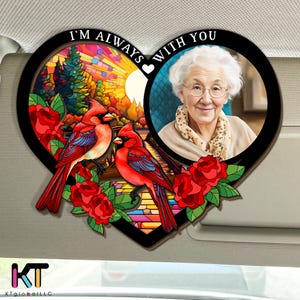 May include: A heart-shaped decorative item featuring a photo of an elderly woman and a stained-glass design with two red cardinals. The text "I'M ALWAYS WITH YOU" is displayed above the image. Red roses and green leaves are also included in the design.