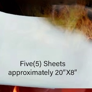 May include: Five (5) sheets of white paper, approximately 20 inches by 8 inches, are on fire. The paper is burning and there is smoke coming from it.