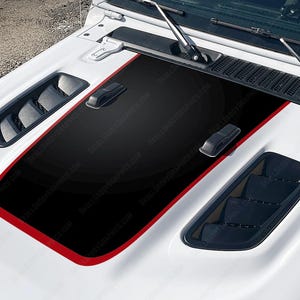 May include: A white Jeep Wrangler hood with a black and red racing stripe decal. The decal has a black background with a red border and a black stripe down the center. The hood has two black air vents on either side of the stripe.