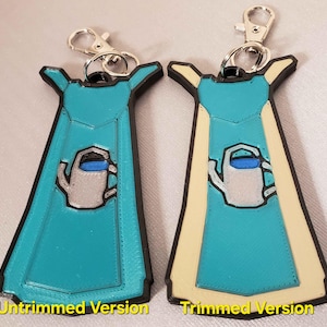 May include: Two versions of a 3D printed keychain featuring a blue watering can with a white spout and a blue handle. The keychain is shaped like a blue apron with a white trim. The left keychain is untrimmed and the right keychain is trimmed.