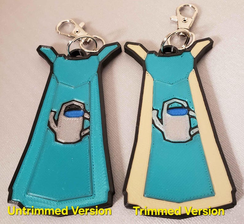May include: Two versions of a 3D printed keychain featuring a blue watering can with a white spout and a blue handle. The keychain is shaped like a blue apron with a white trim. The left keychain is untrimmed and the right keychain is trimmed.