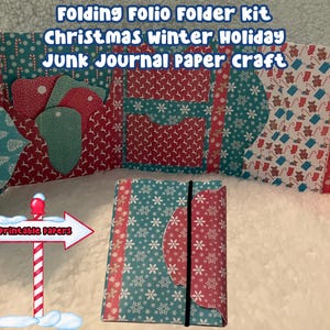 May include: A Christmas-themed junk journal paper craft kit. The kit includes a folding folio folder with pockets and tags, and a closed folio with an elastic band. The folios feature red, teal, and white snowflake and holiday-themed patterns.
