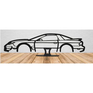 May include: A black metal car silhouette, a profile view of a classic sports car design. The car features details like wheels and windows. It is mounted on a black stand, set against a neutral background, with a wooden surface.