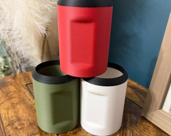 May include: Three 3D-printed drink holders in red, green, and white, each with a black rim. The red holder is stacked on top of the green and white holders. The text "SPEEDLOAD COZIE" is at the bottom of the image.