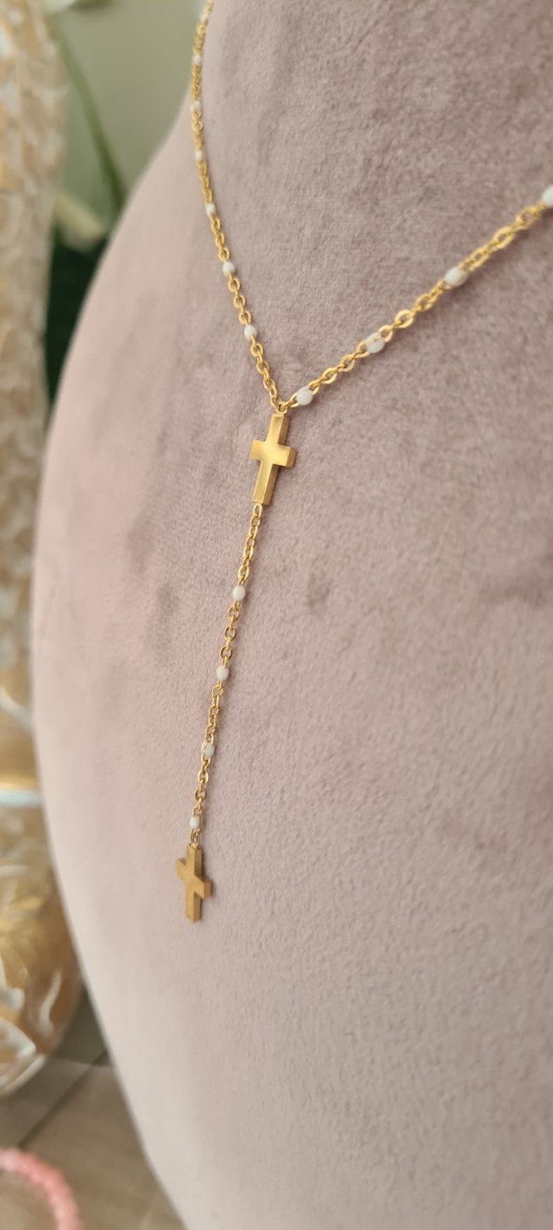Peut inclure: Un collier en cha&icirc;ne dor&eacute;e avec des perles blanches et deux pendentifs en forme de croix dor&eacute;s.