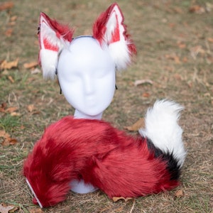 May include: Red and white faux fur fox ears headband with a matching red and black faux fur tail.