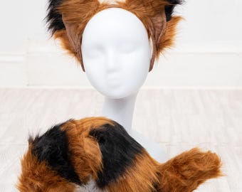 May include: A brown and black faux fur tail with a headband featuring brown and black faux fur ears. The headband and tail are on a white mannequin.