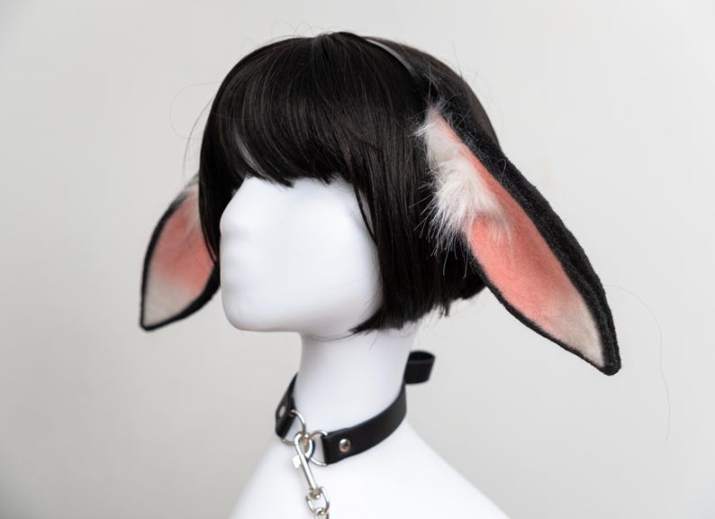May include: A black wig with a white and pink bunny ear headband and a black leather choker with a silver chain.
