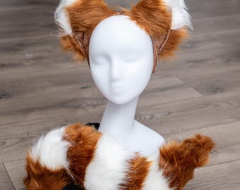 May include: A red and white faux fur tail and headband with brown ears. The headband is worn on a white mannequin head.