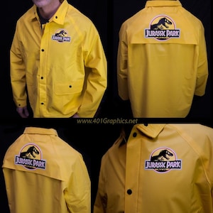 May include: A yellow raincoat with a black Jurassic Park logo on the back and a smaller logo on the left chest. The logo features a dinosaur silhouette.