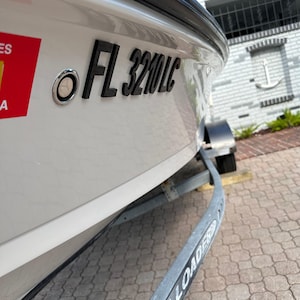 May include: A white ceramic mug with a black handle and the text "But First, Coffee" in a bold, black font. The mug is set against a blurred background, suggesting a cozy setting.
