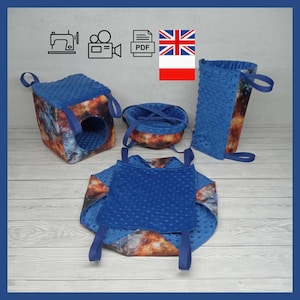 May include: A selection of small pet accessories featuring a galaxy print and blue minky fabric. The set includes a cube hideaway, a round bed, a hanging pouch, and a carrier. Each item has blue straps for hanging or carrying.