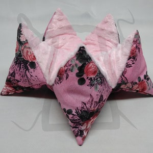 May include: A pink floral fabric storage basket with a soft white lining. The basket is folded into a star shape.