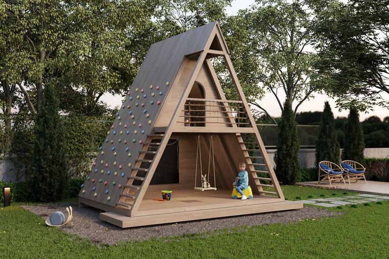 Puede incluir: Una casa de juegos de madera en forma de A con una pared de escalada, un columpio y una peque&ntilde;a terraza. Un ni&ntilde;o est&aacute; sentado en un juguete amarillo en la terraza.