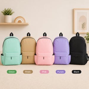 May include: Five backpacks in a row, each featuring a main compartment, a front zippered pocket, and side pockets. The backpacks are available in five distinct solid colors: mint green, khaki, light pink, lavender purple, and solid black.