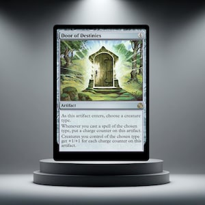 May include: A Magic: The Gathering card titled "Door of Destinies" on a pedestal. The card features an illustration of a glowing door in a forest setting. Text on the card describes its artifact type and abilities. The card is displayed on a gray, tiered pedestal.