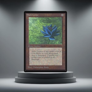 Puede incluir: Una carta coleccionable Black Lotus, un artefacto mono, se muestra en un pedestal gris. La carta presenta una ilustración de una flor de loto azul sobre un fondo verde. El texto de la carta dice "Adds 3 mana of any single color..." y "Illus. Christopher Rush."