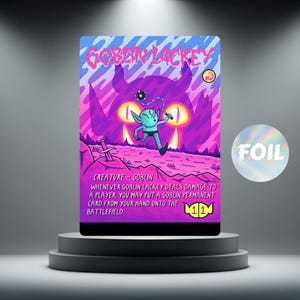 Puede incluir: Una tarjeta coleccionable con un duende y el texto "GOBLIN LACKEY". La tarjeta tiene un acabado de lámina y un fondo morado y rosa con una silueta de monstruo. La tarjeta se muestra en un pedestal gris. Medidas en centímetros.