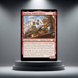 May include: A Magic: The Gathering trading card titled Ragavan, Nimble Pilferer, featuring a white monkey pirate sitting on a wooden chest filled with gold treasures, jewellery, and a fan, with red borders and game text printed on the card face.