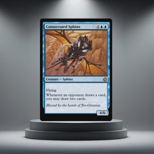 Pode incluir: Um cartão azul Consecrated Sphinx, apresentando uma criatura alada com uma ilustração detalhada. O texto do cartão inclui "Criatura - Esfinge" e "Voar". O cartão é exibido em um pedestal cinza.