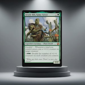 May include: A green and black trading card depicting "Bristly Bill, Spine Sower," a legendary plant druid. The card shows a detailed illustration of a creature with cactus-like features. Text includes game instructions and the quote, "Wake up, little ones. There's a new day ahead."