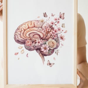 Könnte beinhalten: Ein gerahmter Wandkunstdruck mit einer Illustration eines menschlichen Gehirns in sanften Rosa- und Violetttönen. Das Gehirn ist mit blühenden Kirschblüten, Rosen und zarten Schmetterlingen verziert, die ein florales Motiv auf weißem Grund bilden.