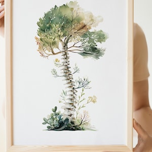 May include: Watercolor art print in a wooden frame. The artwork depicts a spine transformed into a tree, with green and brown foliage at the top and plant life at the base. The spine is white and the frame is light brown.