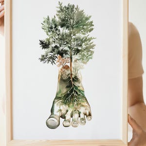 May include: Watercolor art print featuring a foot with tree roots and a lush green tree growing from it. The artwork is framed in a light-colored wooden frame, creating a nature-inspired theme.