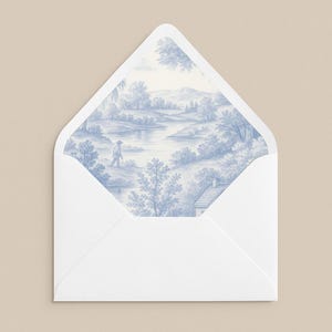 Puede incluir: Un sobre blanco con un diseño de paisaje toile de Jouy azul y blanco en el interior. La ilustración representa a una persona caminando cerca de un río, árboles y una casa. El sobre está abierto, revelando la obra de arte detallada.