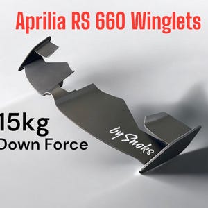 Puede incluir: Un alerón gris oscuro para una motocicleta Aprilia RS 660. El alerón tiene un diseño curvo con el texto "by Snoks" en blanco. La imagen también incluye el texto "15kg Down Force" y "Aprilia RS 660 Winglets" en rojo.