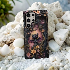 May include: Black phone case featuring a 3D dragon design. The case has a detailed relief of a dragon in a forest setting with flowers. The dragon has red eyes and purple wings. The case is surrounded by a dark brown frame.