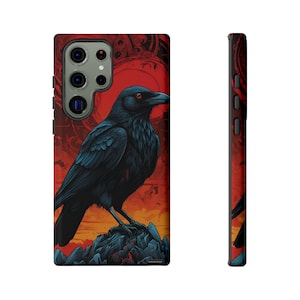 May include: A black raven with red eyes perched on a rocky outcrop against a red and orange sunset background. The raven is the focal point of the design, with intricate details in its feathers. The background features a stylized design with a circular shape reminiscent of a sun.