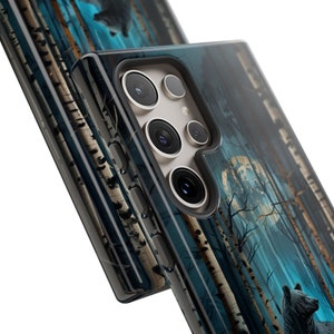 May include: A clear phone case with a dark blue and white forest scene. The case has a cutout for the camera lens and a black border. The scene features a full moon, trees, and a bear.