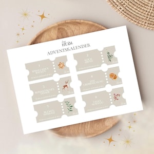 May include: A beige Advent calendar with six ticket-shaped sections, each with a number and a German word. Decorative elements include a star, a deer, and sprigs. The calendar is on a wooden plate.