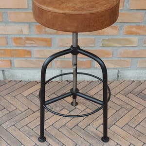 Tabouret à hauteur d'assise réglable, structure en métal, assise en bois garnie de mousse et de cuir, fabrication artisanale, style industriel, noir mat
