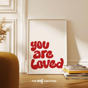 This You Are Loved Wall Art is a Christian inspired wall art. It has a funky playful font text in color Red on white background. Perfect for Valentines Day decor, Girls Bedroom Decor, and a gift for daughter