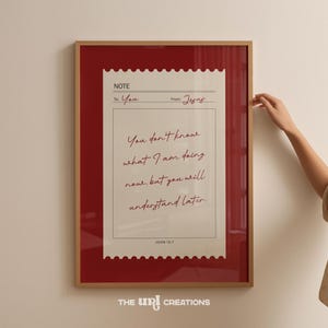 May include: Framed print with a red border and a light-colored interior. The print features a handwritten note with the text "You don't know what I am doing now, but you will understand later." The text is in red, with the words "To: You" and "From: Jesus".