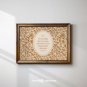 May include: A framed print with a brown wooden frame. The print features a beige background with a repeating pattern of brown leaves. An oval in the center contains the text "To every thing there is a season, and a time to every purpose under the heaven."