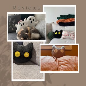 May include: A collection of decorative pillows including two white ghost-shaped pillows, a black cat-shaped pillow with yellow eyes, and a brown cat-shaped pillow. One pillow features the text "LITTLE STAR" and another reads "HAND PICKED PUMPKIN".