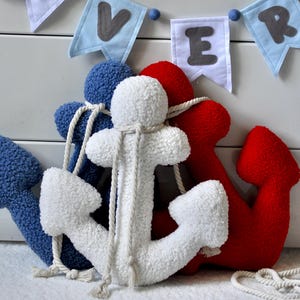 May include: Three plush anchor toys in blue, white and red. The anchors are tied together with white rope.