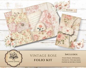 May include: A vintage rose folio kit with a floral design. The kit includes a folio base, ephemera, pockets, two backing papers, and instructions. The kit features a light beige and pink colour scheme with rose and butterfly accents. The text "Vintage Rose Folio Kit" is visible.