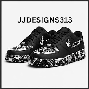 May include: Pair of black and white sneakers with a splatter paint design. The shoes have a black base with white paint splatters on the toe, sides, and sole. The Nike swoosh is visible on the side. The text "JJDESIGNS313" is above the shoes.