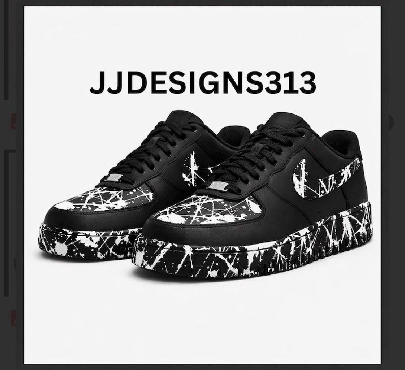 May include: Pair of black and white sneakers with a splatter paint design. The shoes have a black base with white paint splatters on the toe, sides, and sole. The Nike swoosh is visible on the side. The text "JJDESIGNS313" is above the shoes.