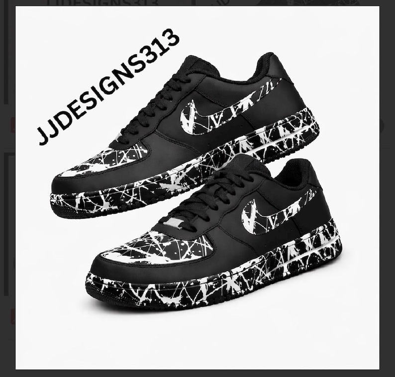 May include: Pair of black and white sneakers with a splatter paint design. The shoes feature a white Nike swoosh and black laces. The text "JJDESIGNS313" is visible in the upper left corner.