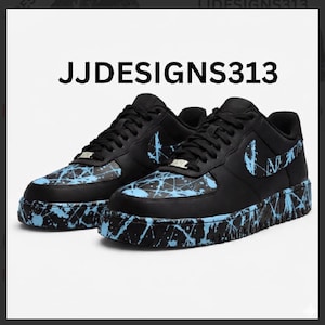 May include: Pair of black sneakers with light blue splatter paint design. The shoes feature the text "JJDESIGNS313" and a light blue Nike swoosh logo on the side.