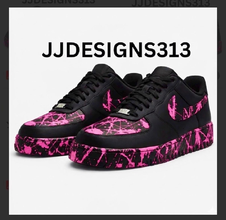 May include: Pair of black sneakers with pink splatter paint design on the toe, side, and sole. The Nike swoosh is pink. The text "JJDESIGNS313" is printed in white on the top of the image.